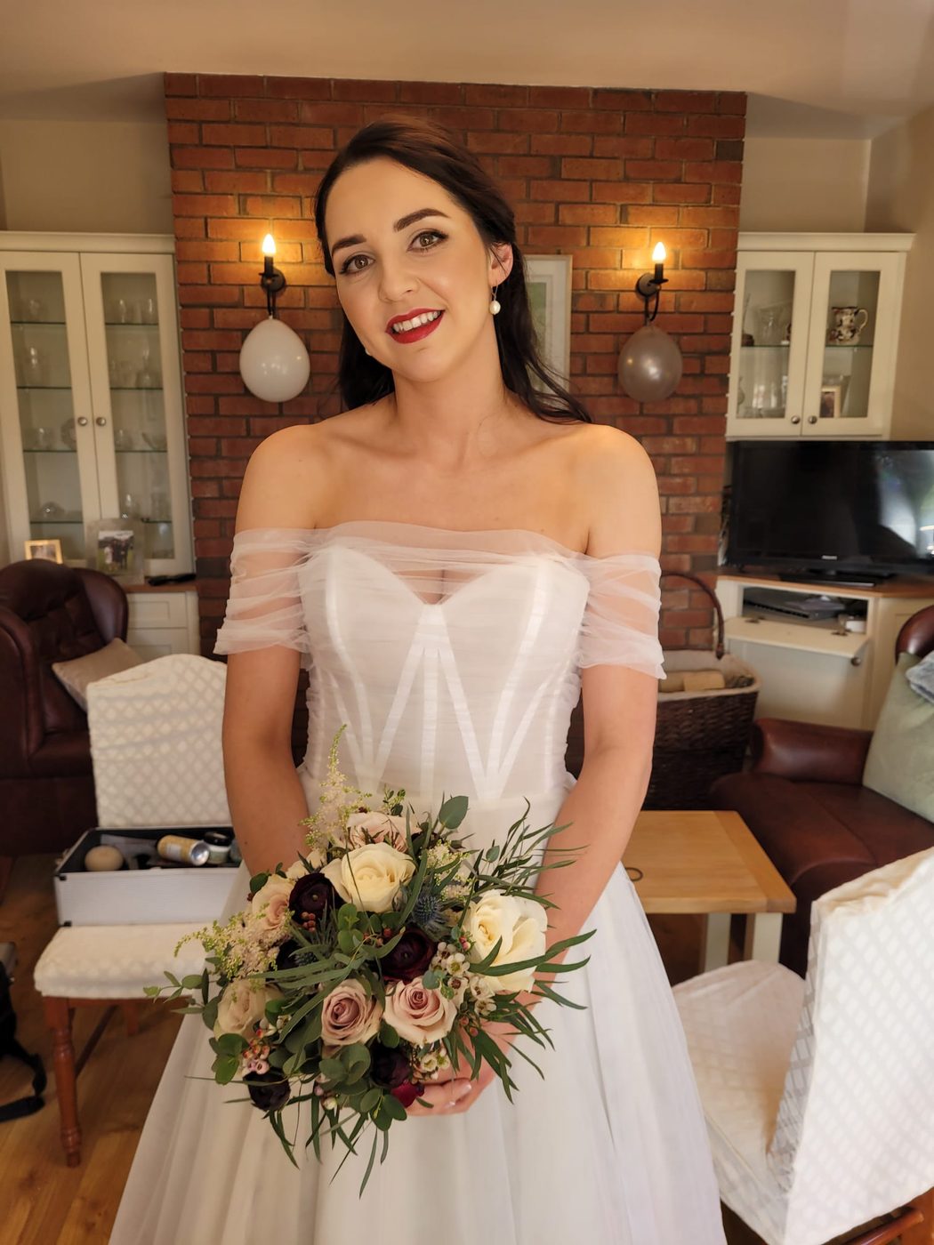 Bride with soft brunette waves holding her bouquet, styled at INCH Hair Design