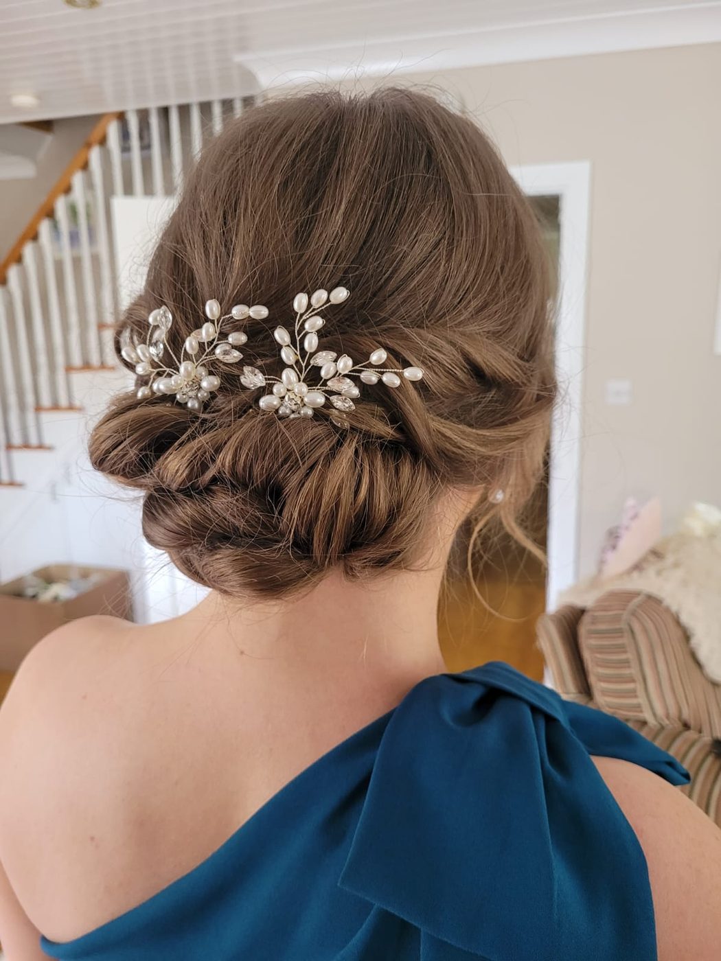 Bridal low bun with a pearl hairpiece, styled at INCH Hair Design